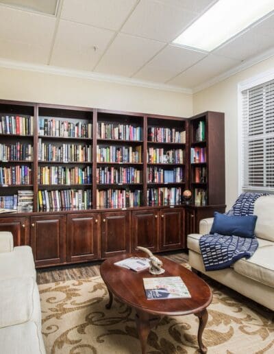 Private dining room with table, chairs, table settings, overhead light fixture, cabinets, and wall decor